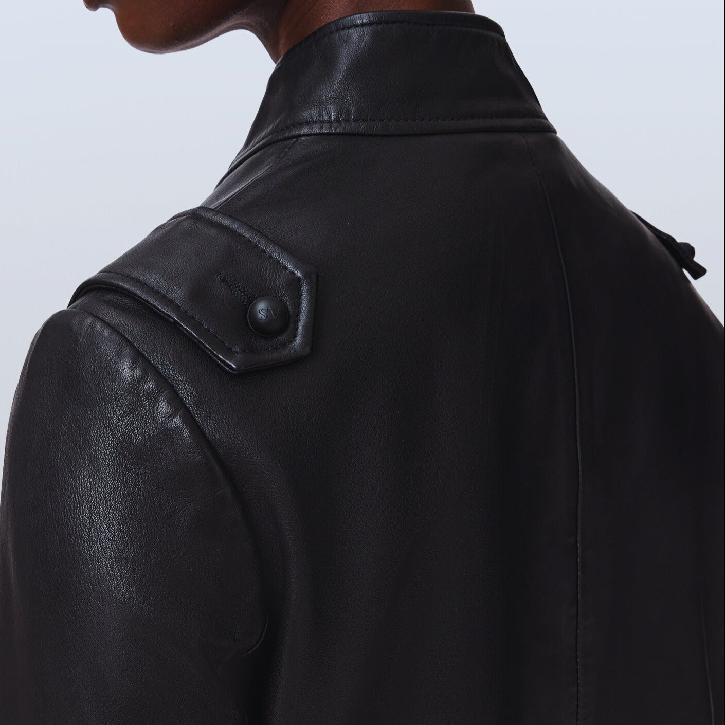 Black leather military jacket hardware detail – premium genuine leather power dressing
