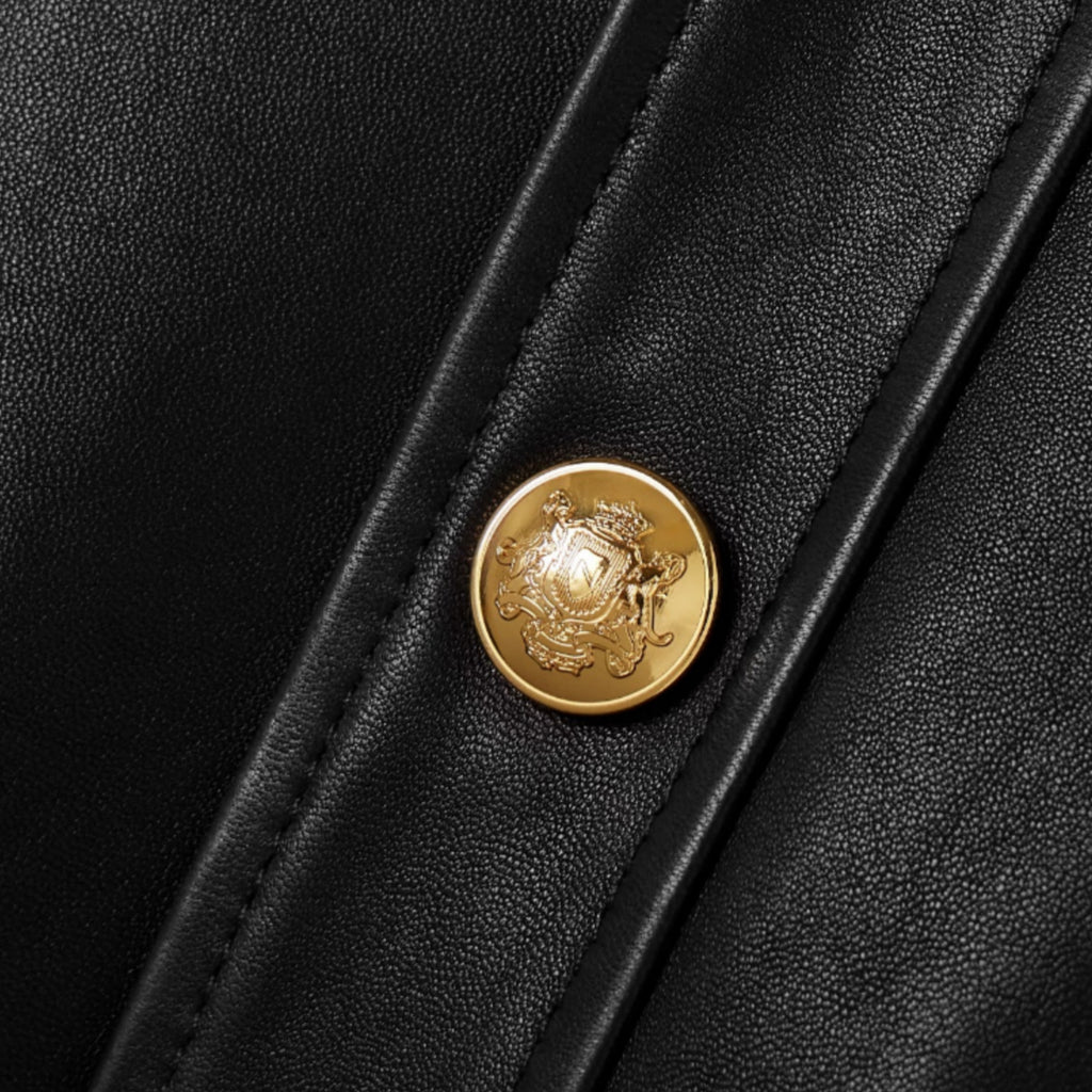 Gold button detail on women’s black leather jacket