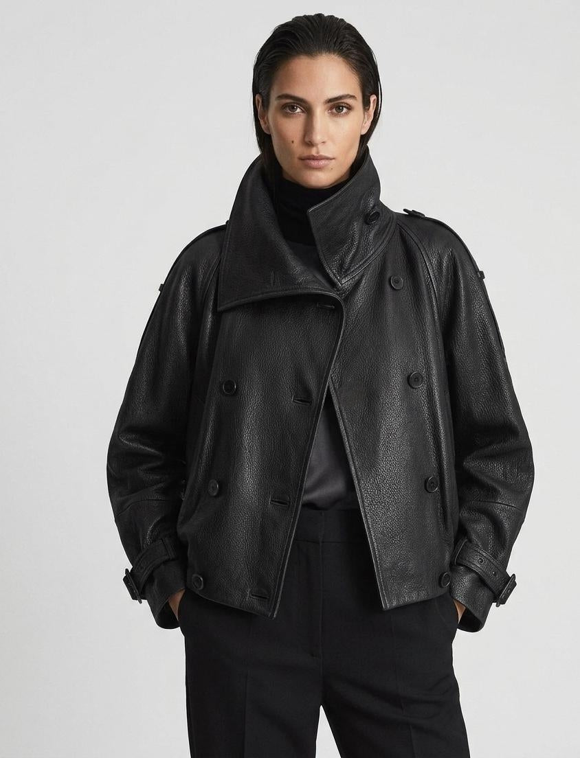 Person wearing a black leather jacket on a plain background